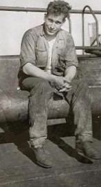 Joanne Kane’s uncle Wilfred Richard sitting on the deck of a ship, wearing work clothes.