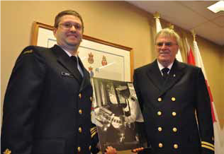 Jason Morphet (left) and James Morphet (right), dressed in uniform, holding a picture of Robert Morphet.