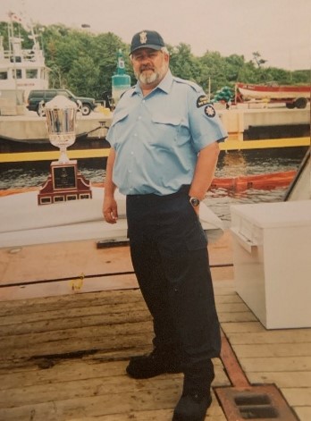 John Scott dans son uniforme de la GCC sur le quai.